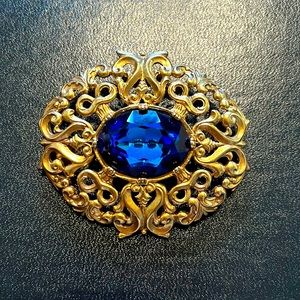 Edgar Berebi gold filagree brooch with blue stone.